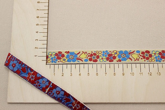 Жак.лента 17мм Красно-бирюзовые цветы на бледном телесно-желтом