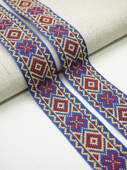 Жак.лента 32мм Красно-желтые снежинки с ромбиками на васильковом